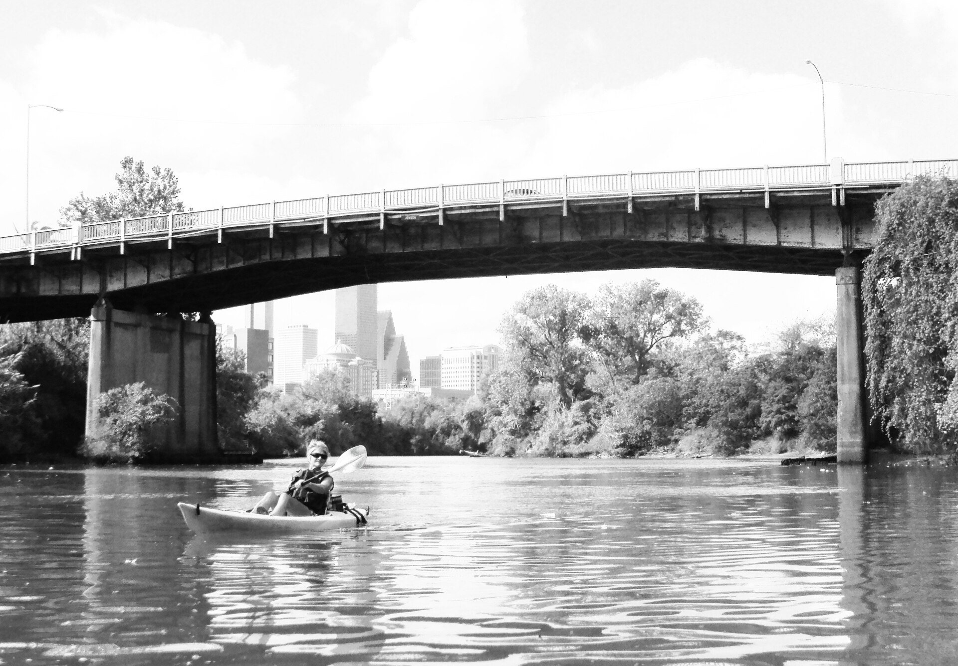 Kayaker on Buffalo Bayou beneath the Jensen Drive bridge