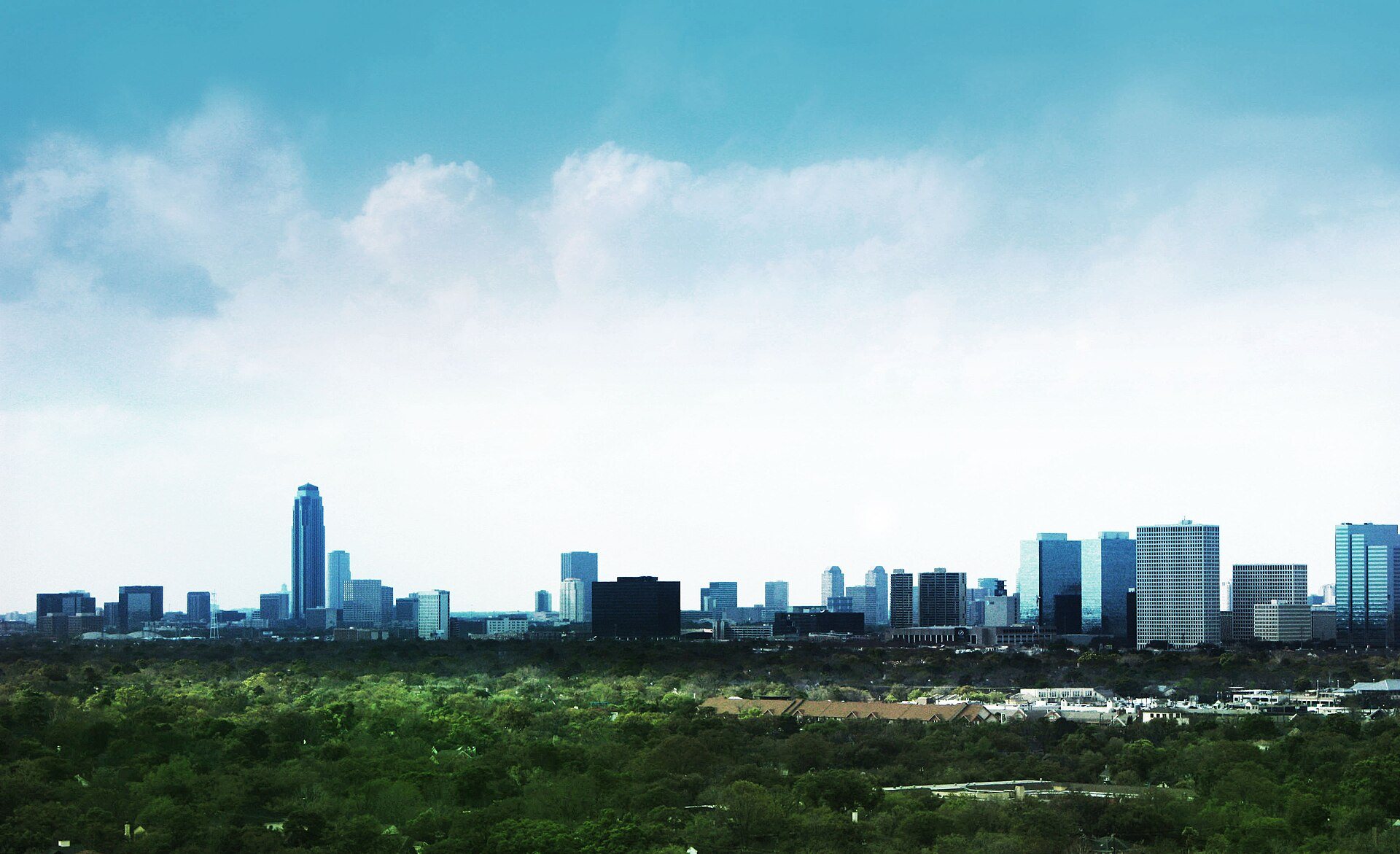 Uptown Houston skyline above a canopy of trees