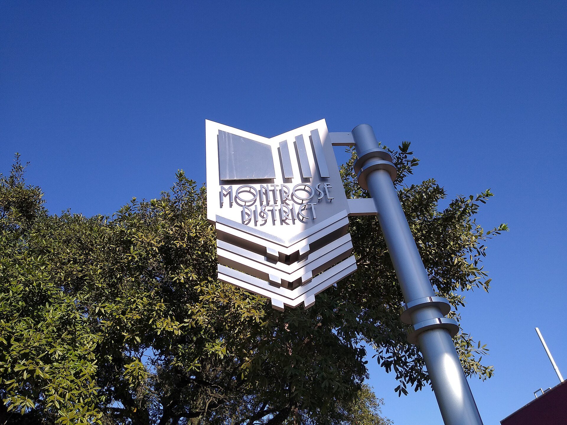 Montrose district street sign against trees and blue sky