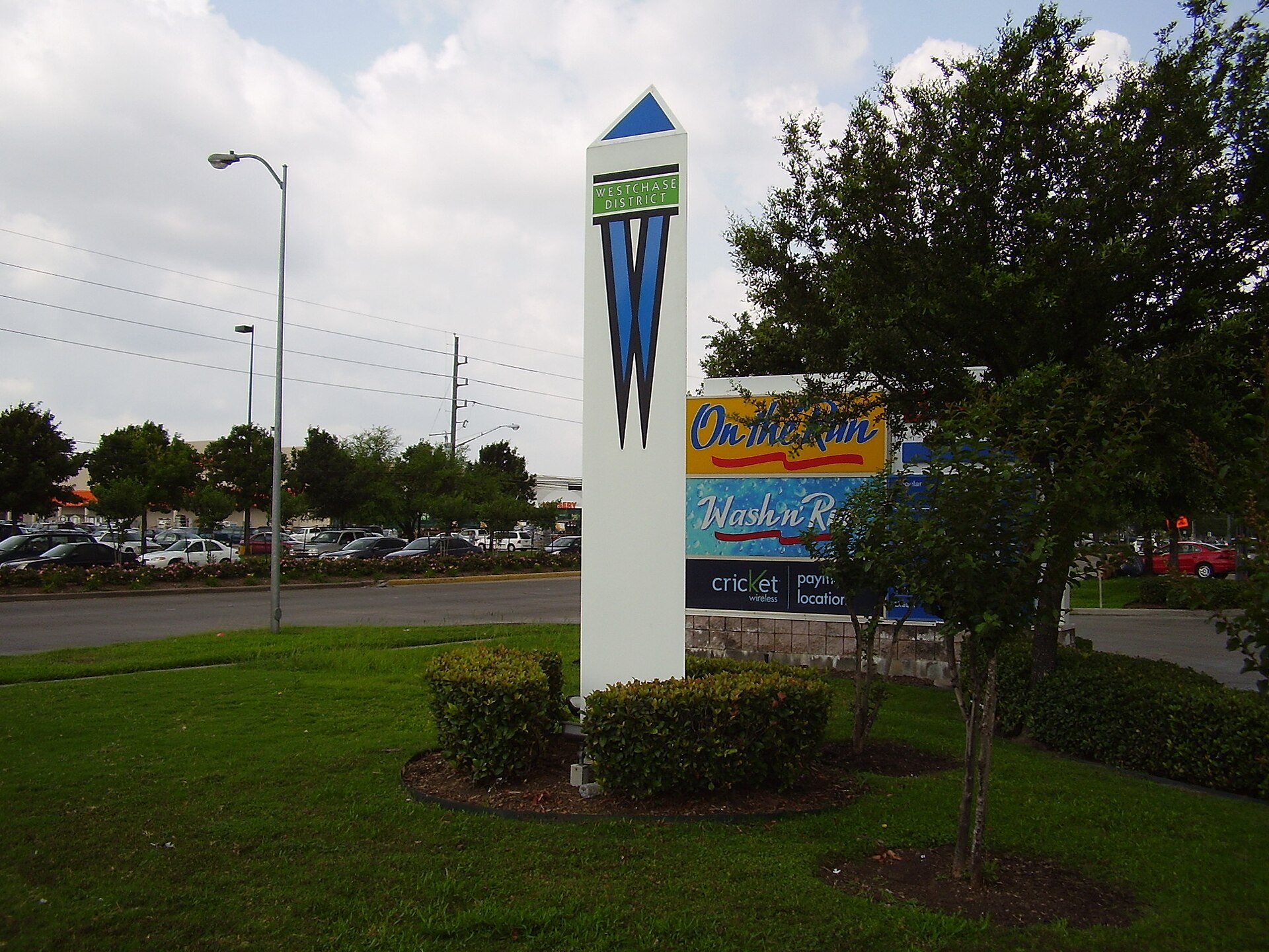 Westchase District marker along a landscaped Houston street